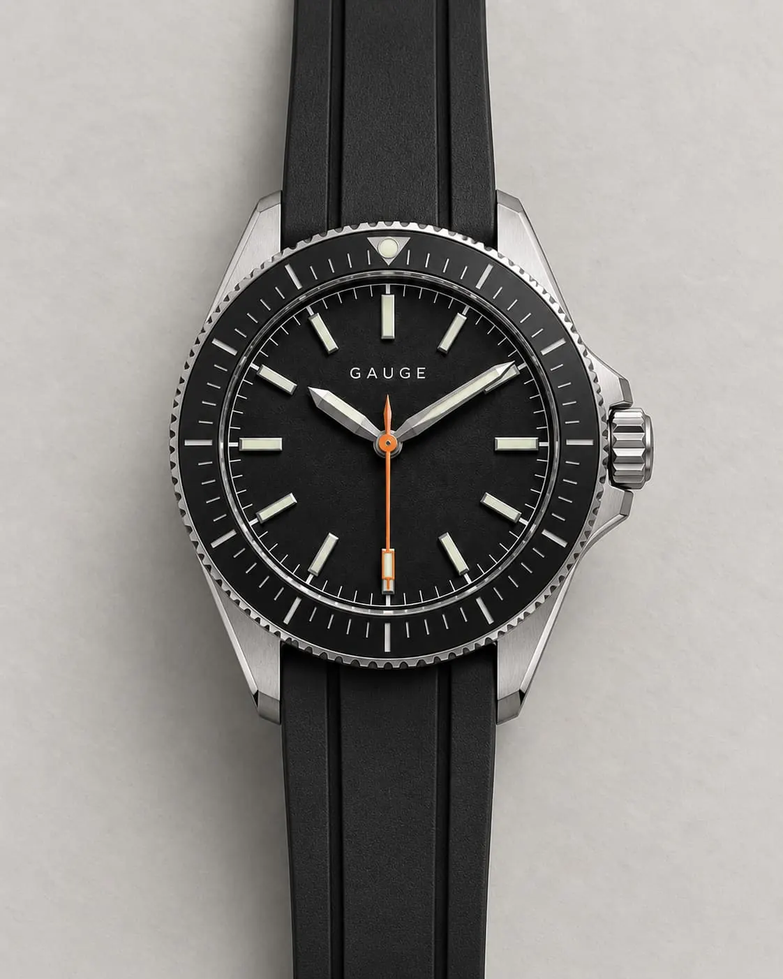 GAUGE-02 Depth, black dial and bezel, black rubber strap, front-on on a warm-grey ground steel plate.