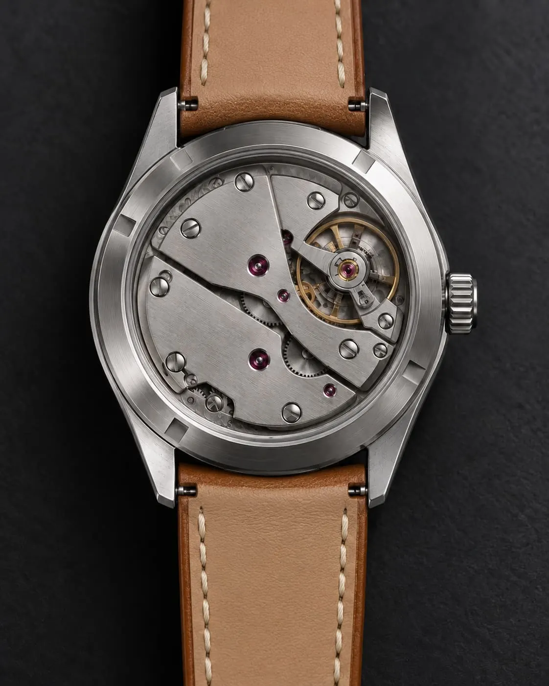 GAUGE-03 Bench case back, the hand-wound G-12 movement seen through sapphire, on a tan leather strap.