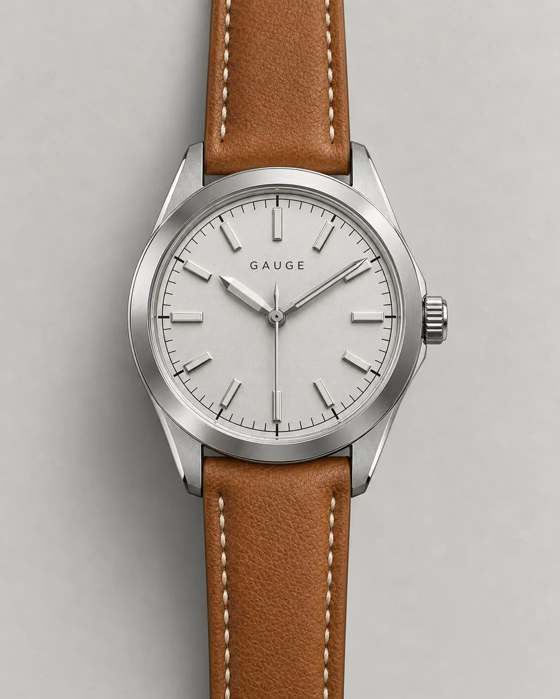 GAUGE-03 Bench, silver dial, tan leather strap, front-on on a warm-grey ground steel plate.